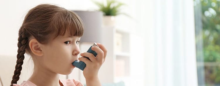 child using an inhaler for asthma