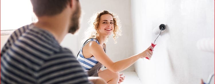 man and woman painting a bedroom together