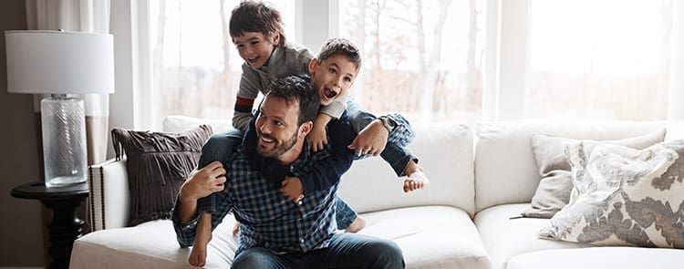 dad with his two kids playing in the living room