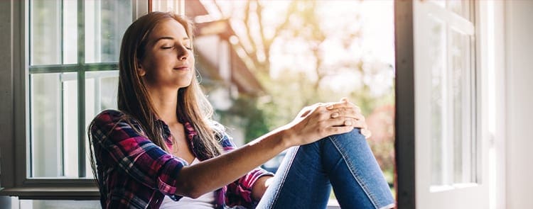 woman enjoying a beautiful fall day in her home by the window