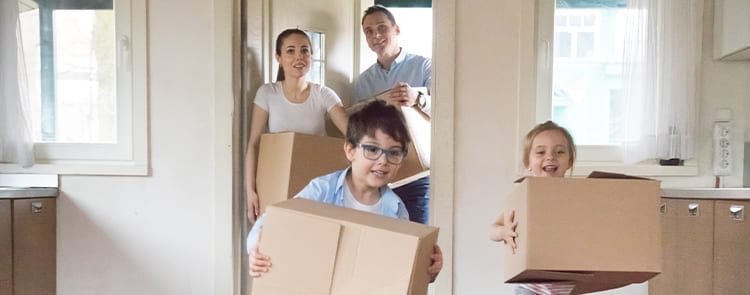 family moving boxes into their new home