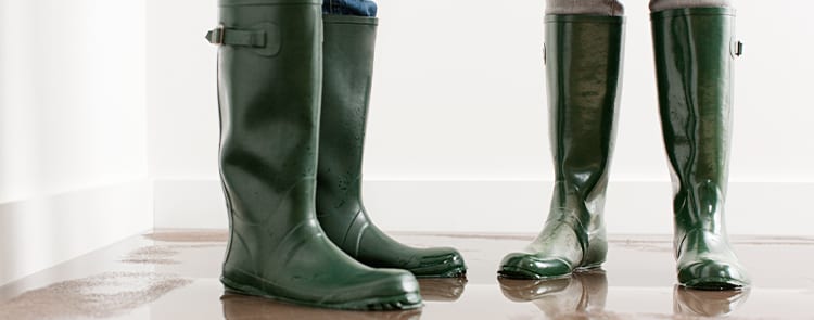 two people standing in water with water boots